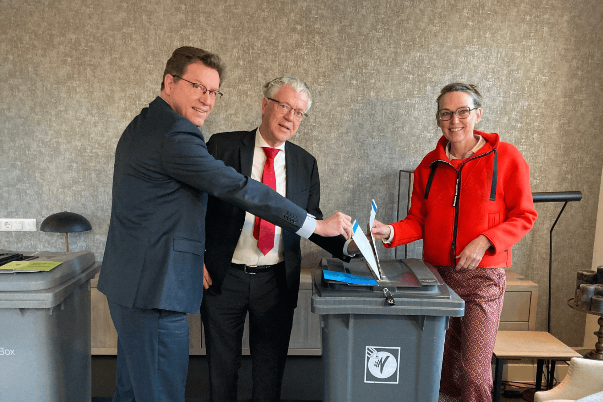 Dijkgraaf Hetty Klavers, commissaris van de Koning Leen Verbeek en burgemeester Roger de Groot houden hun stembiljet boven de stembus.